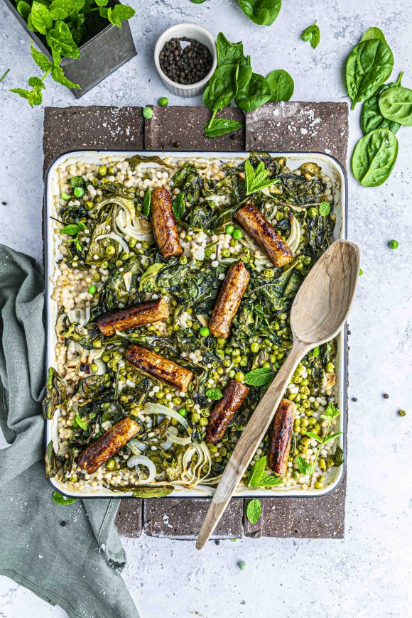 Traybake met parelcouscous, vegan worstjes, erwten en spinazie en munt